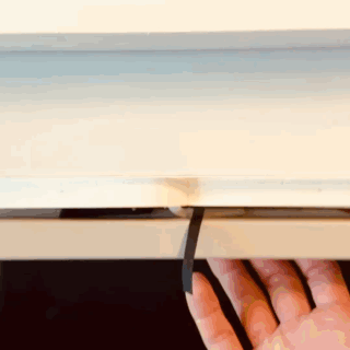 A desk drawer opening to reveal a half-finished notebook inside